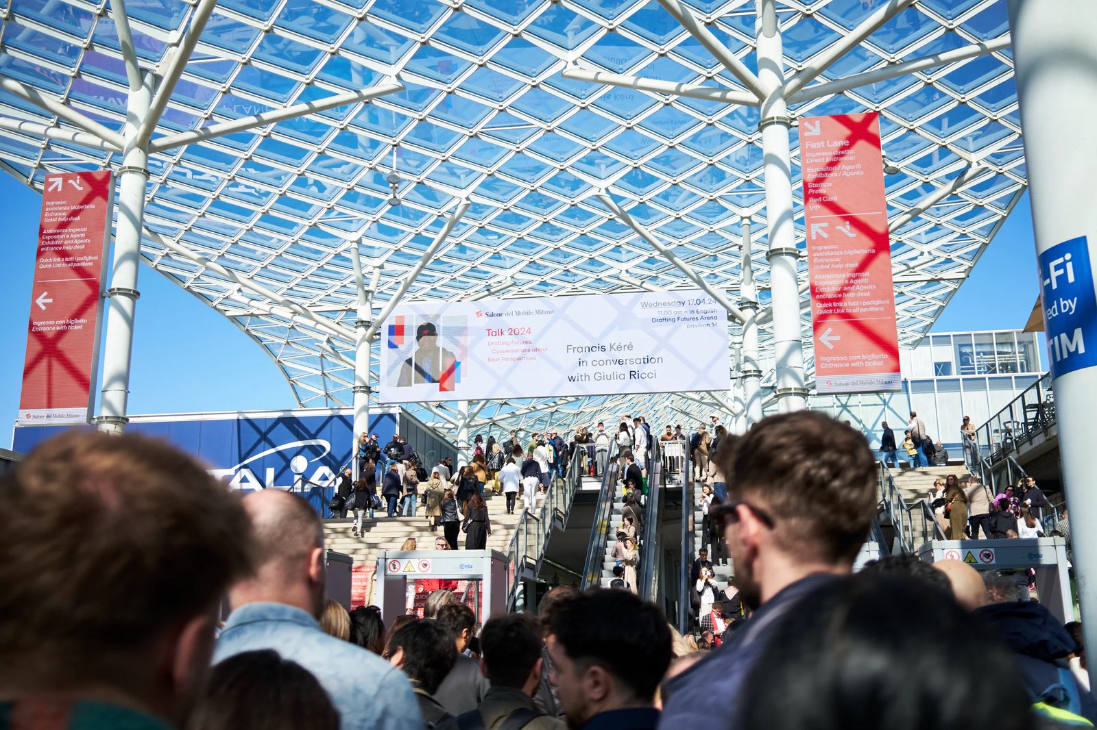 Visitors beneath the glass canopy at Fiera Milano Rho