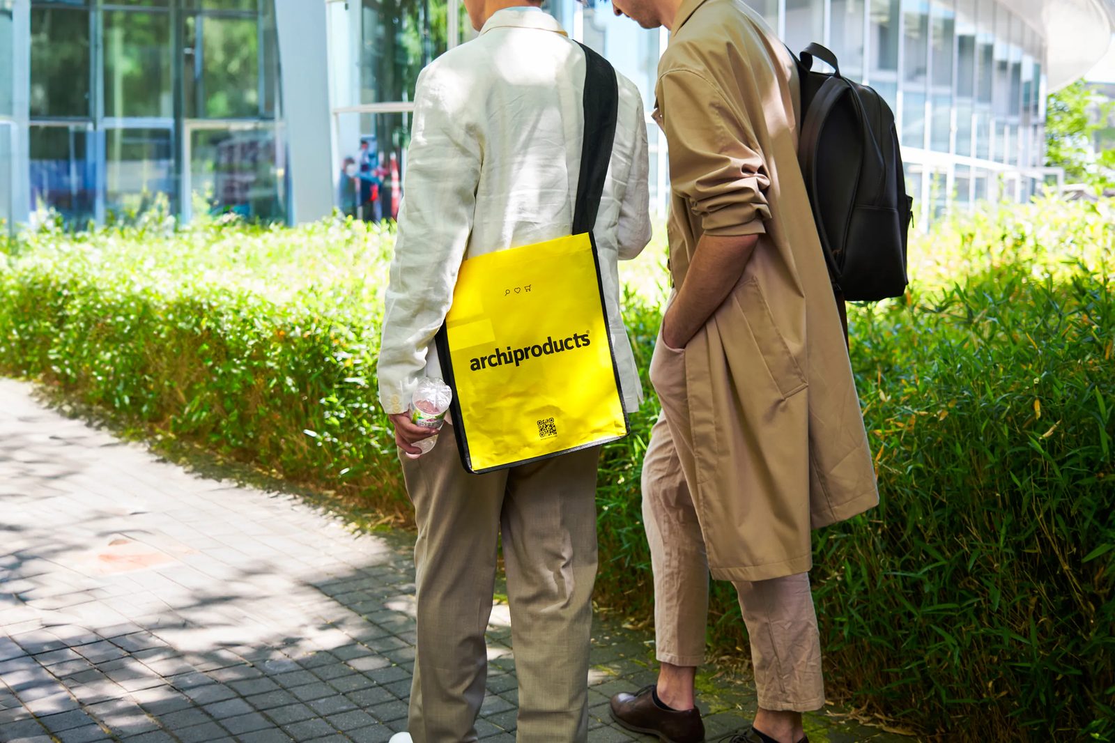 Two visitors with Archiproducts bags at the fair