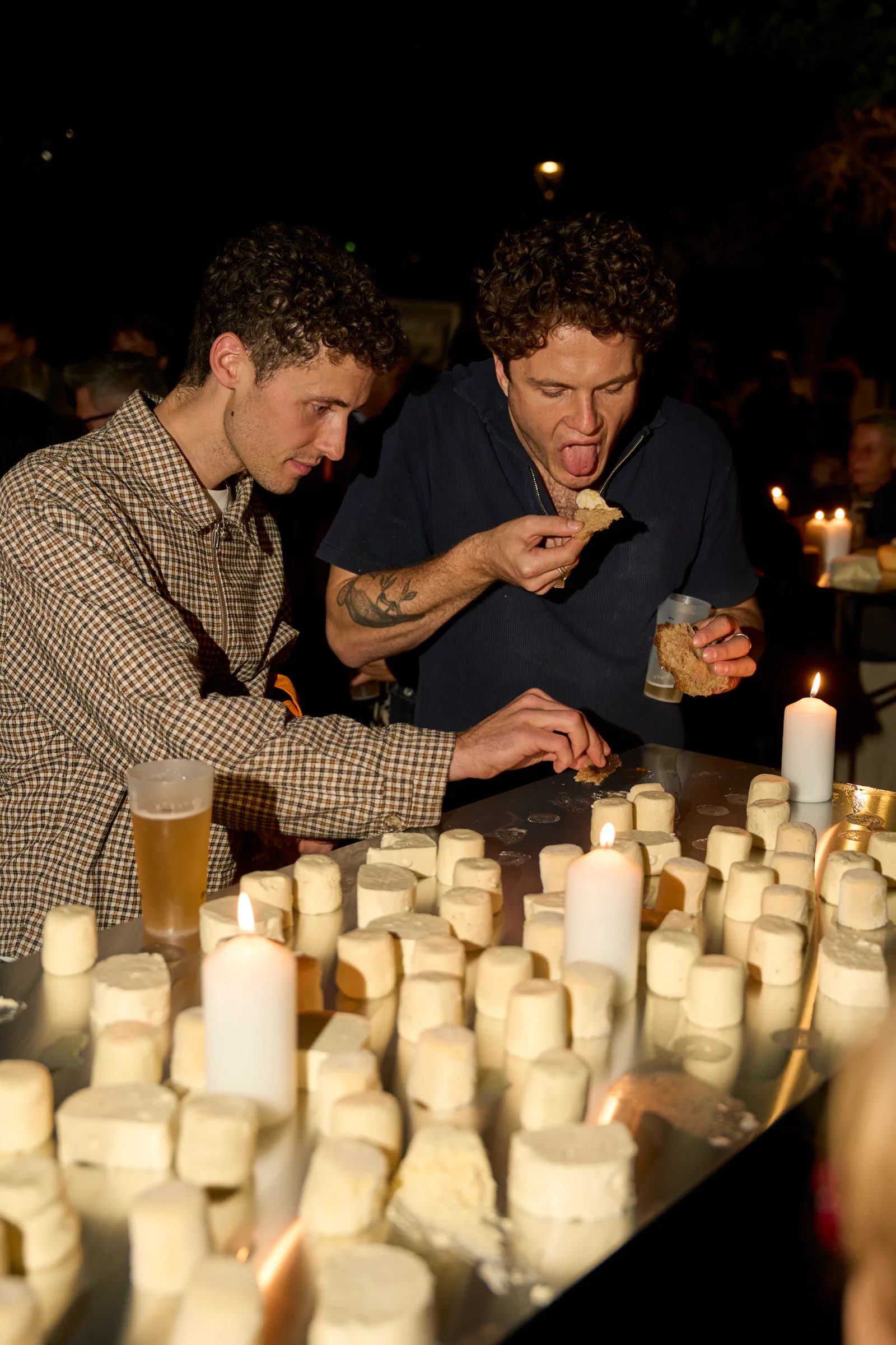 Partecipanti attorno a un’installazione illuminata da candele