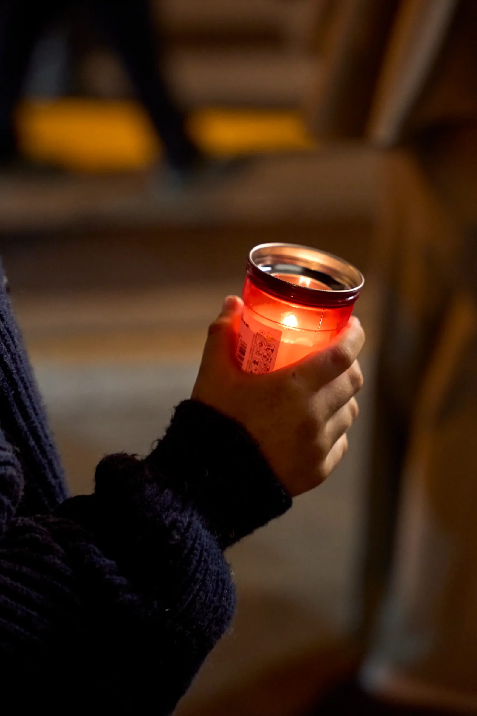 Dettaglio di una mano e di un barattolo alla luce serale