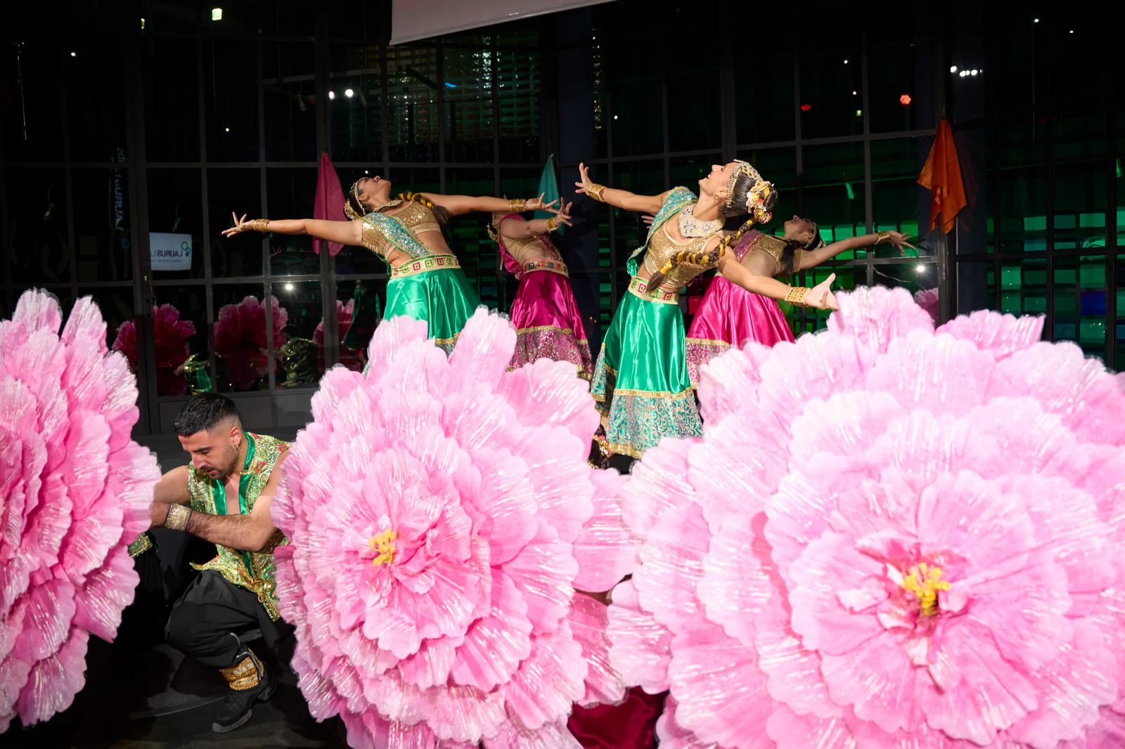 Performance with green costumes and stage flowers