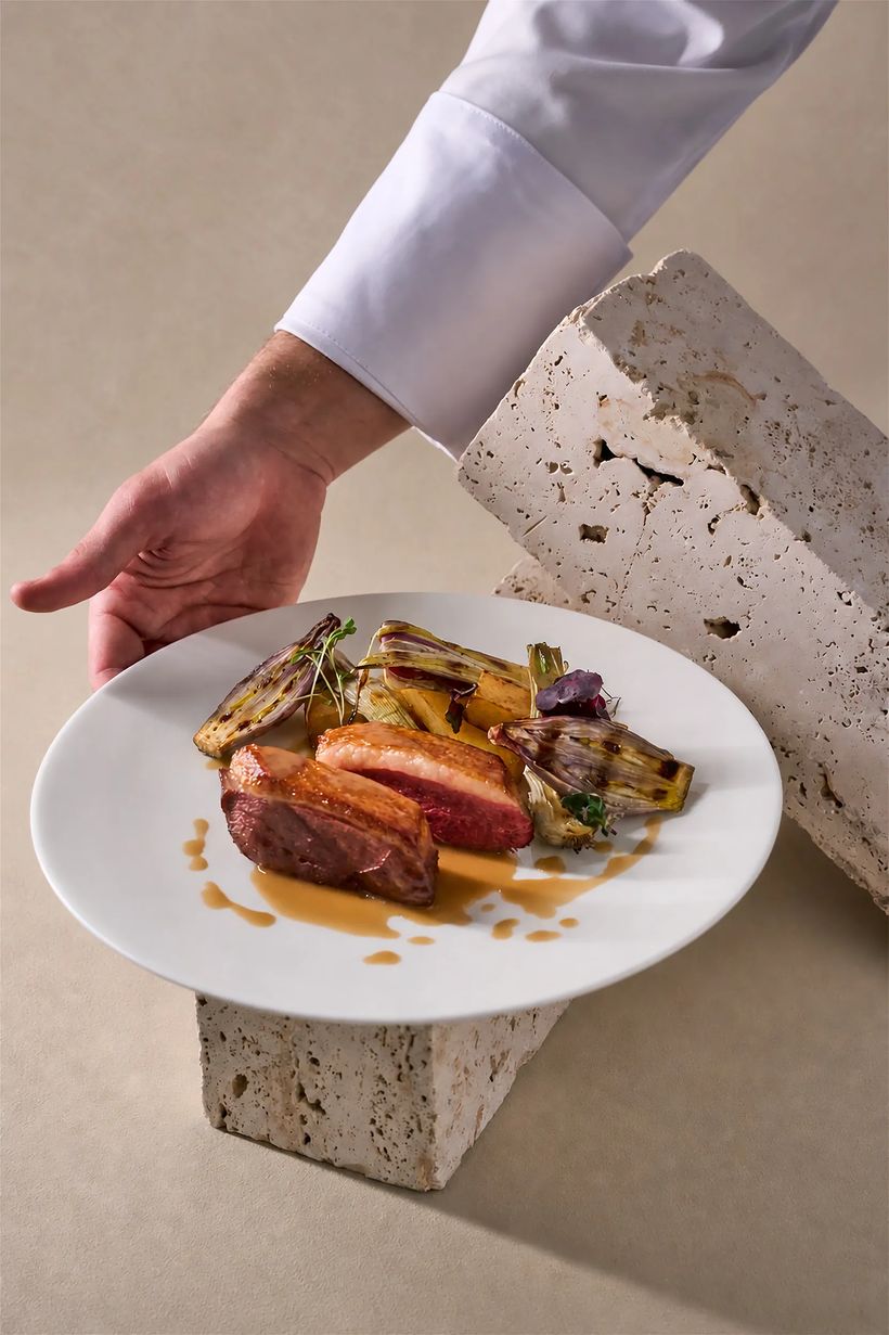Petto d'anatra scottato con radicchio grigliato e arancia servito su travertino — fotografia food professionale ristorante Milano