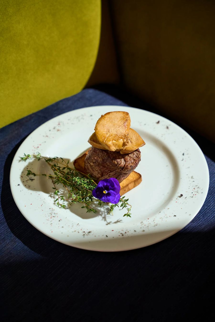 Filetto di manzo con patate arrosto, timo e fiore edule viola su piatto bianco — secondo di carne fine dining, fotografo ristorante Alchimia Milano