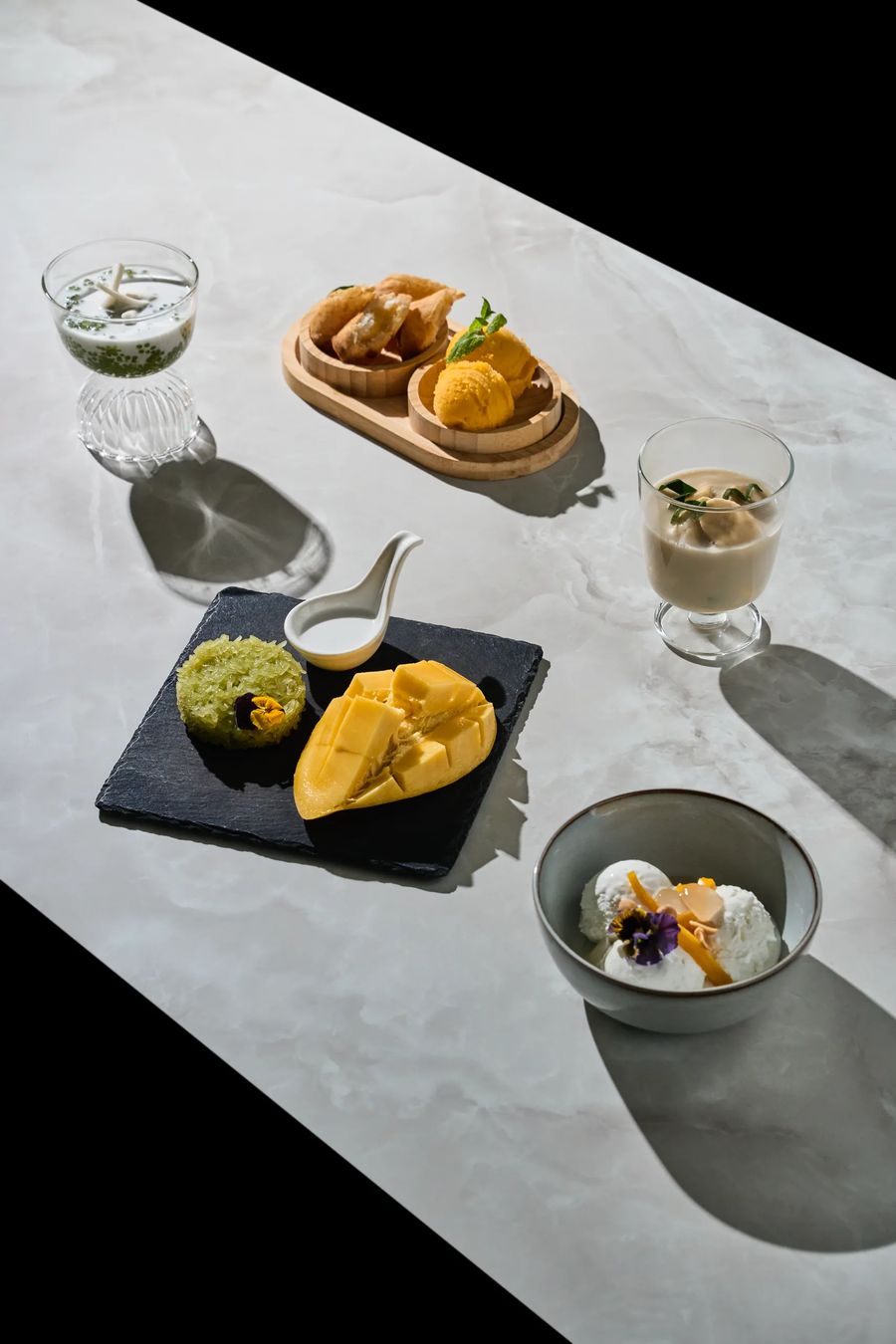 Dessert thai: mango sticky rice, spring roll fritti e gelato al mango su tavolo — fotografia dolci orientali Thai Lounge Milano
