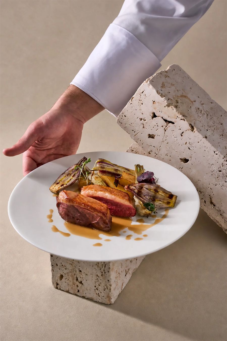 Petto d'anatra scottato con radicchio grigliato e arancia servito su travertino — fotografia food professionale ristorante Milano
