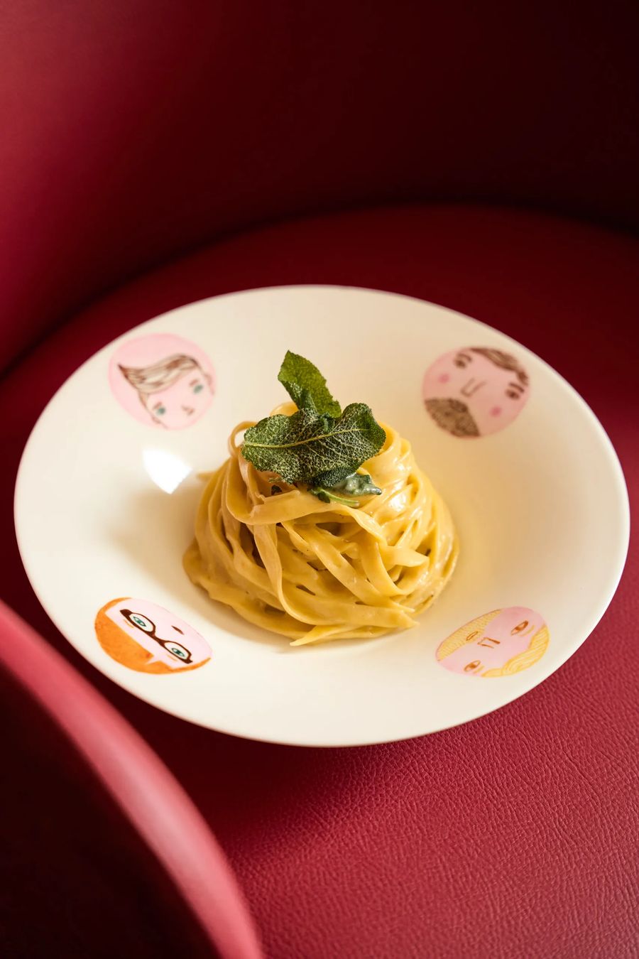 Tagliatelle al burro e salvia su piatto artistico con ritratti illustrati — pasta all'uovo artigianale, fotografo food FATA Milano