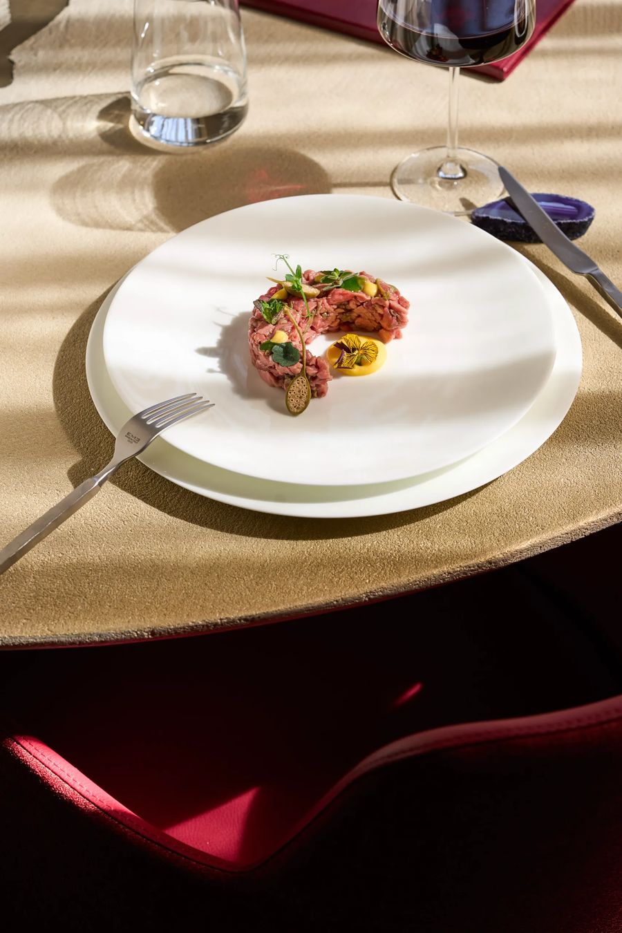 Tartare di manzo con maionese e fiori eduli sul tavolo del ristorante FATA — antipasto crudo, fotografo gastronomia Milano