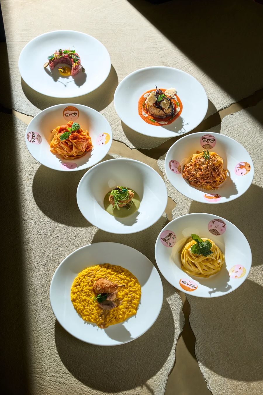Sette piatti del menu FATA su tavolo: pasta, risotto, secondi e pesce — flatlay fotografia gastronomica ristorante Milano