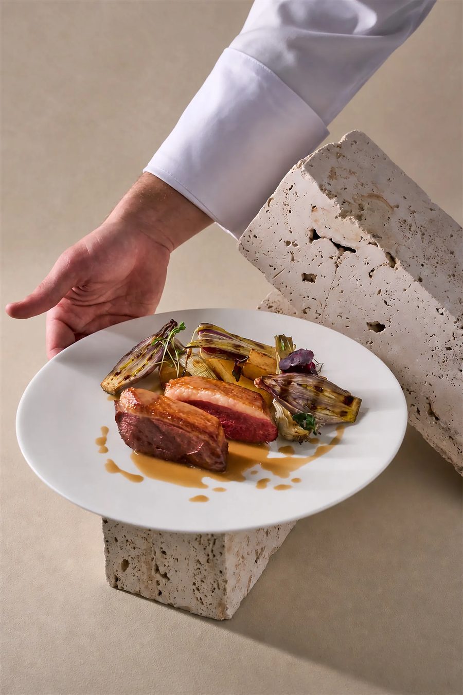 Petto d'anatra scottato con radicchio grigliato e arancia servito su travertino — fotografia food professionale ristorante Milano